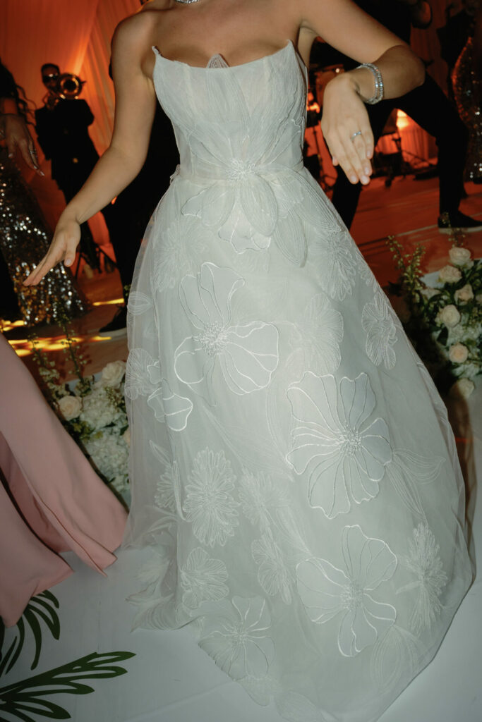 Person in embroidered gown dances at formal event.