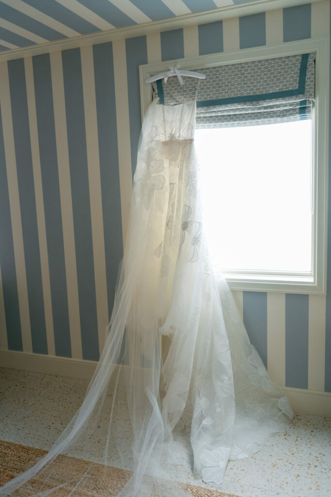 White floral wedding dress glowing in sunlight.