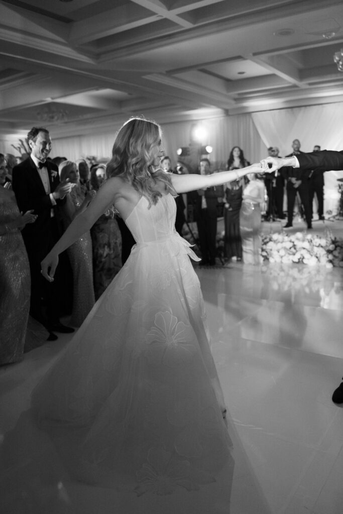 Bride and partner dance as guests celebrate.