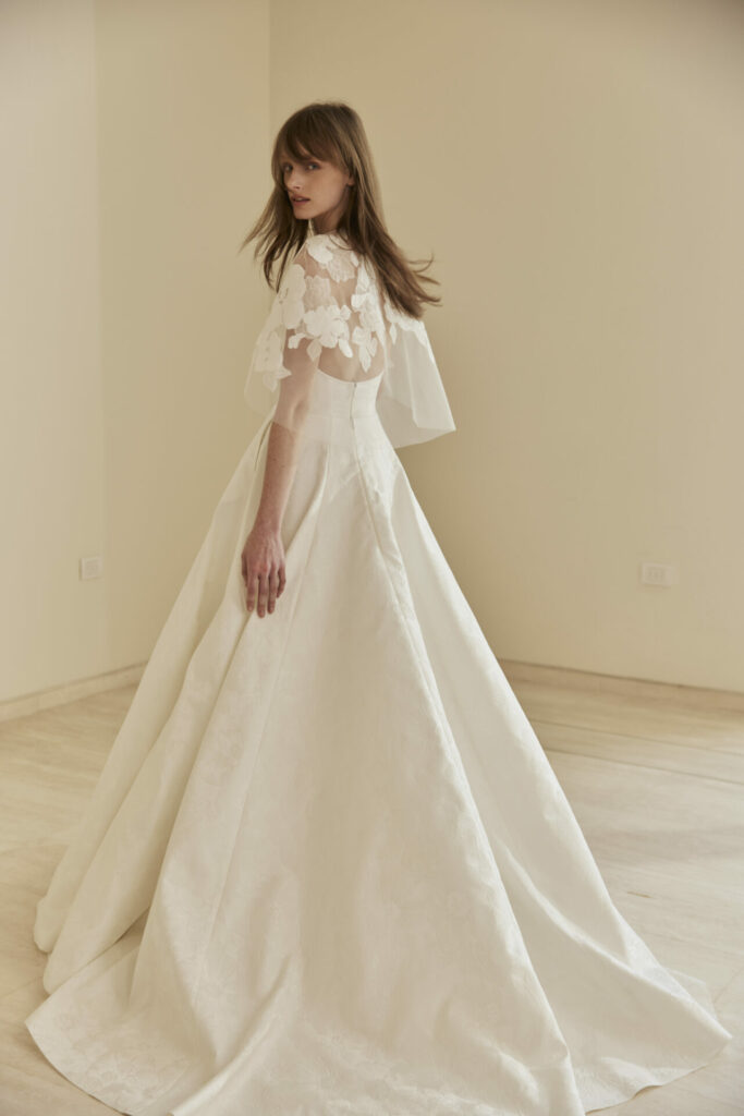 Woman in white Clea dress, looking back.