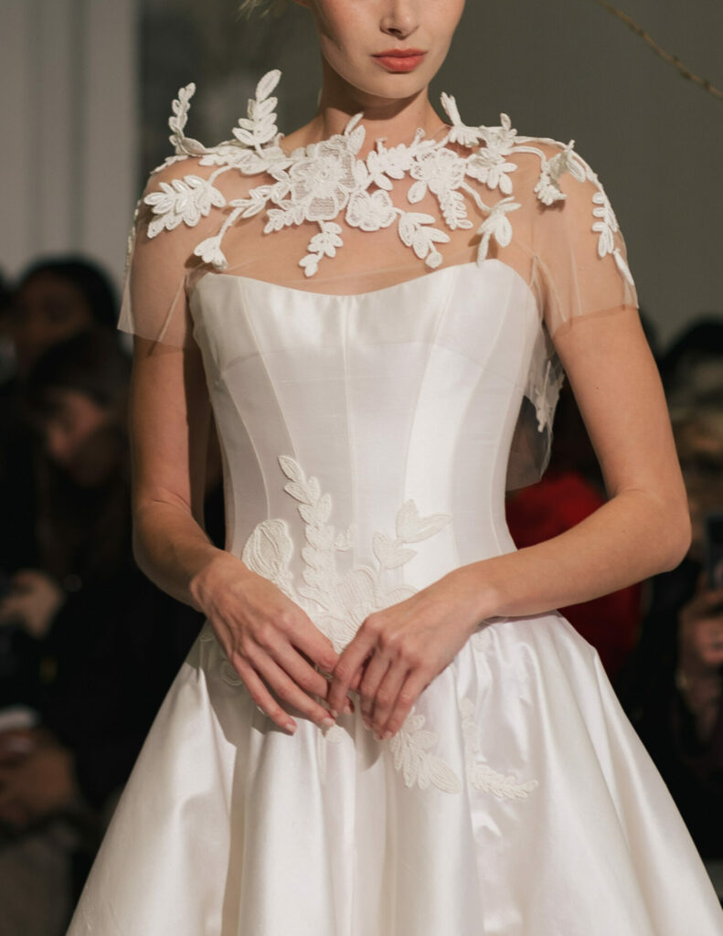 Model in white Clea gown on runway.