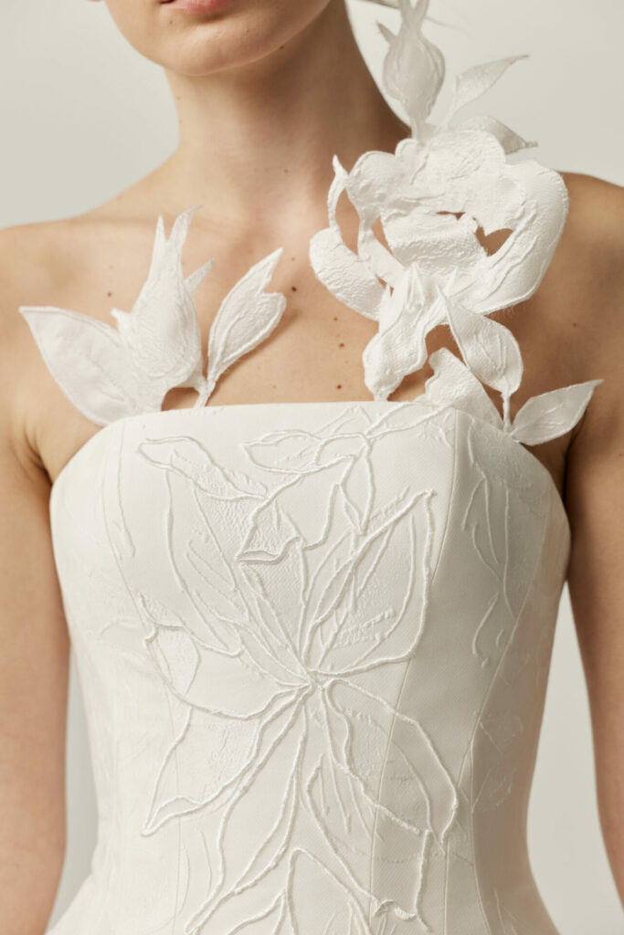Woman in white strapless floral Clea gown.
