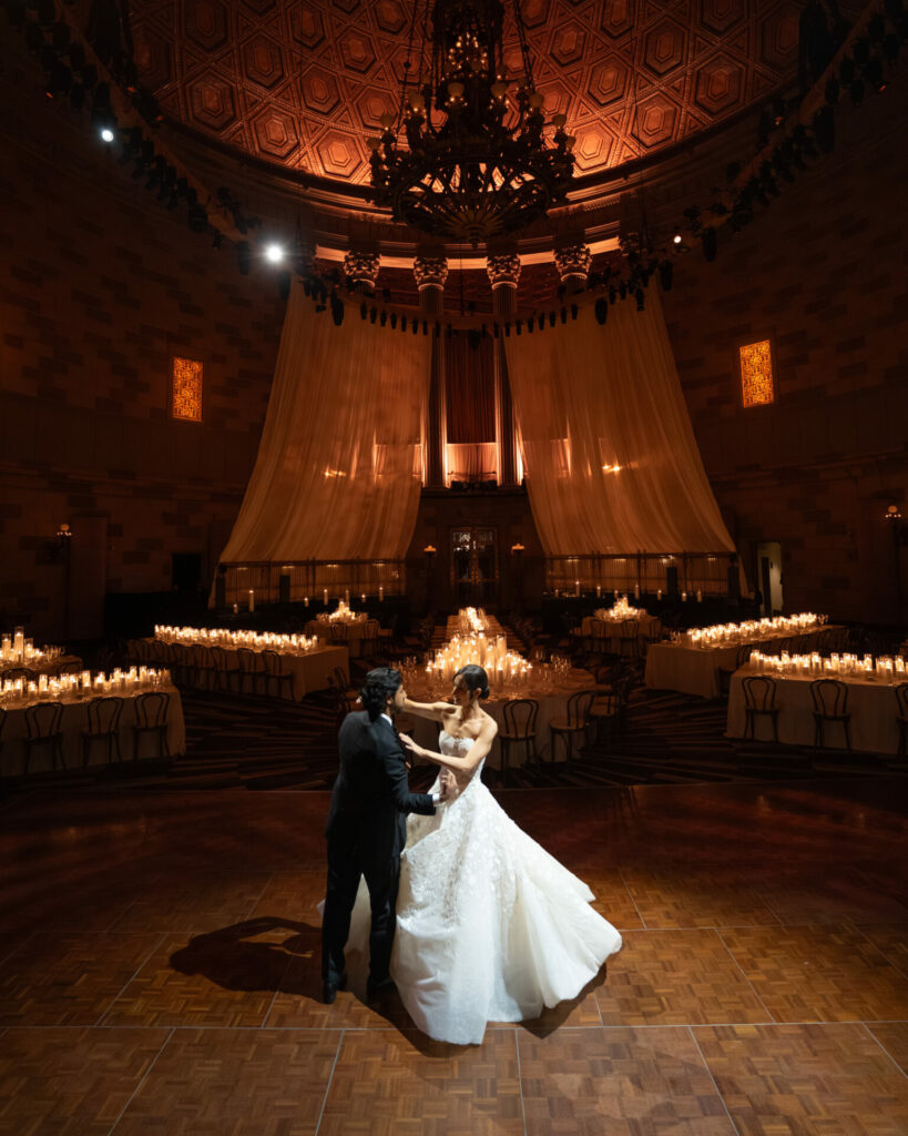 Bride and groom dancing in a luxurious ballroom.