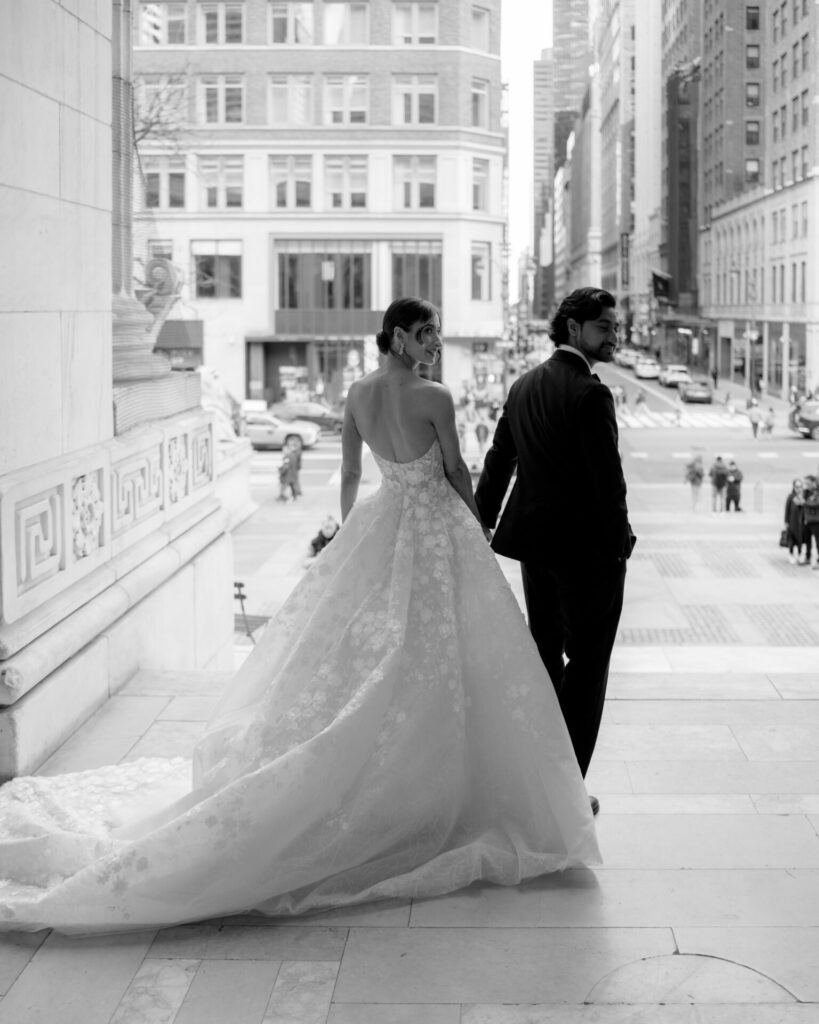 Bride and groom smiling on city steps.