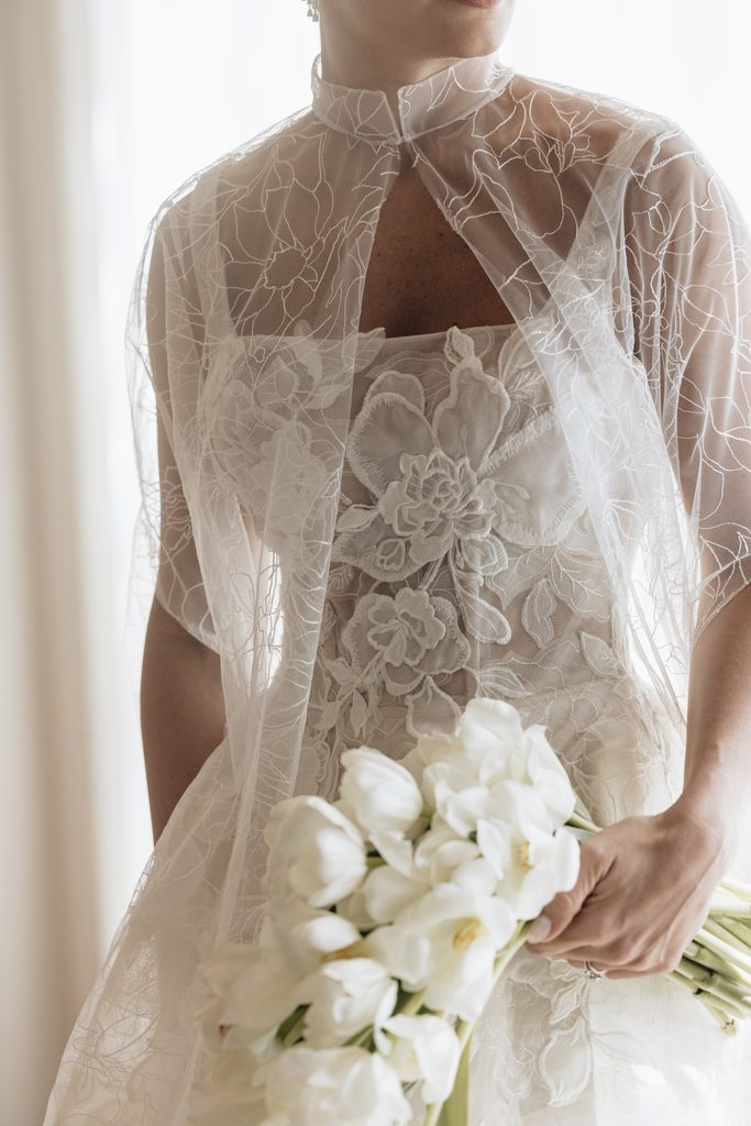 Katya Ruiz in lace dress, sheer cape, tulips.